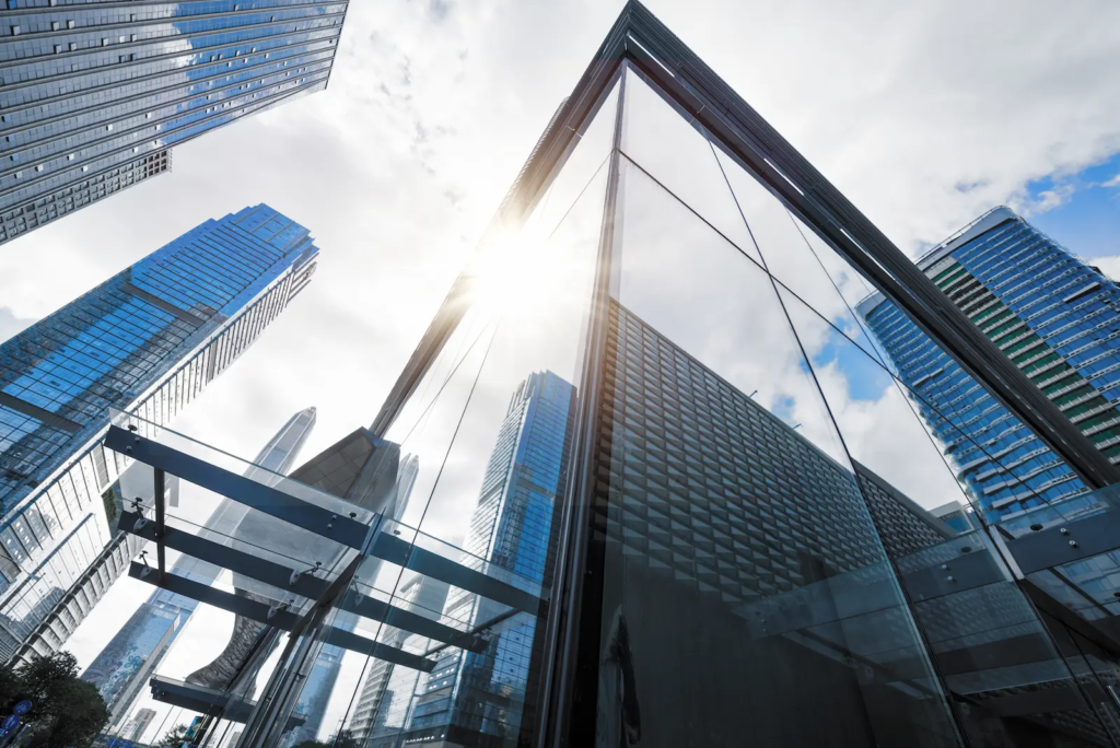 Modern glass office towers and corporate buildings reflecting the global business environment and international commerce.